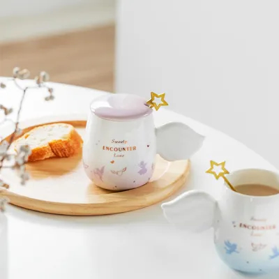 comprar Encantadora caneca de cerâmica com alças de asas de anjo e misturador de estrela de ouro adornado com suaves gradientes de rosa e azul claro online manufacture